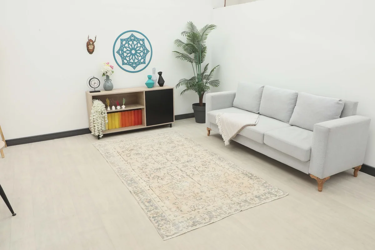Vintage Anatolian rug displayed in a bright living room setting with a light gray sofa and modern decor.