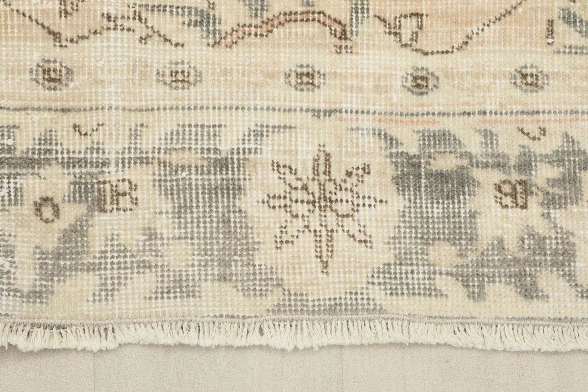 Close-up of the rug's end, showing the short fringe and the border design.