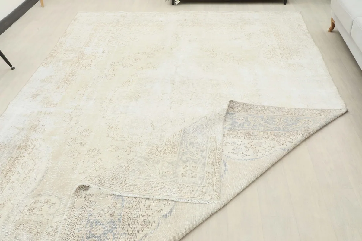 Large rug partially folded to show the full size and the back of the hand-knotted construction