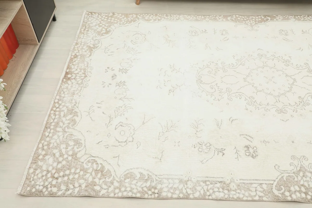 Detail view of another corner, capturing the subtle variations in the beige border and ivory field.