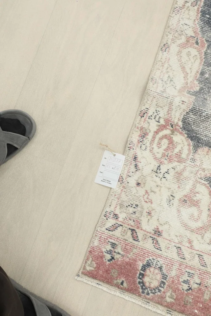 Close-up of a care label attached to the runner, next to a foot for scale