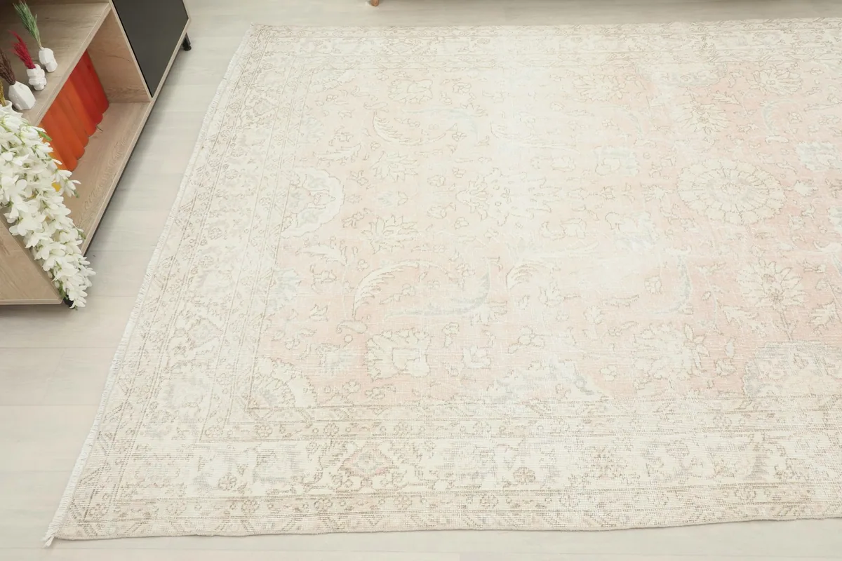Angled view focusing on the other side of the rug, showing faded floral motifs