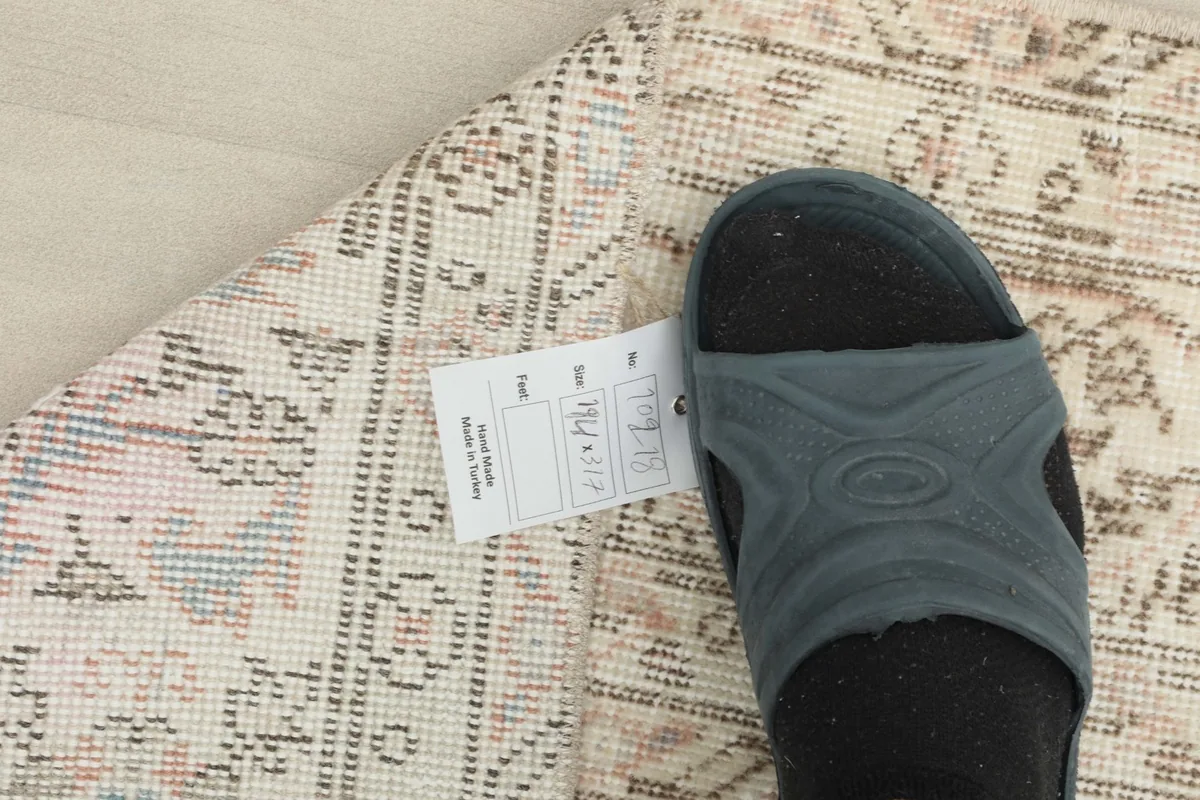 Foot and size tag on the rug, indicating the dimensions and origin