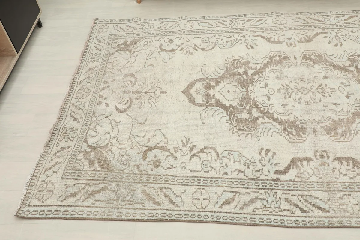 Another angled view of the vintage rug, highlighting the subtle color variations and patterns
