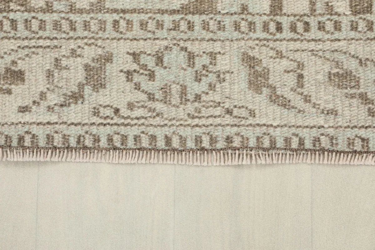 Close-up of the short, natural fringe and the finished edge of the vintage rug