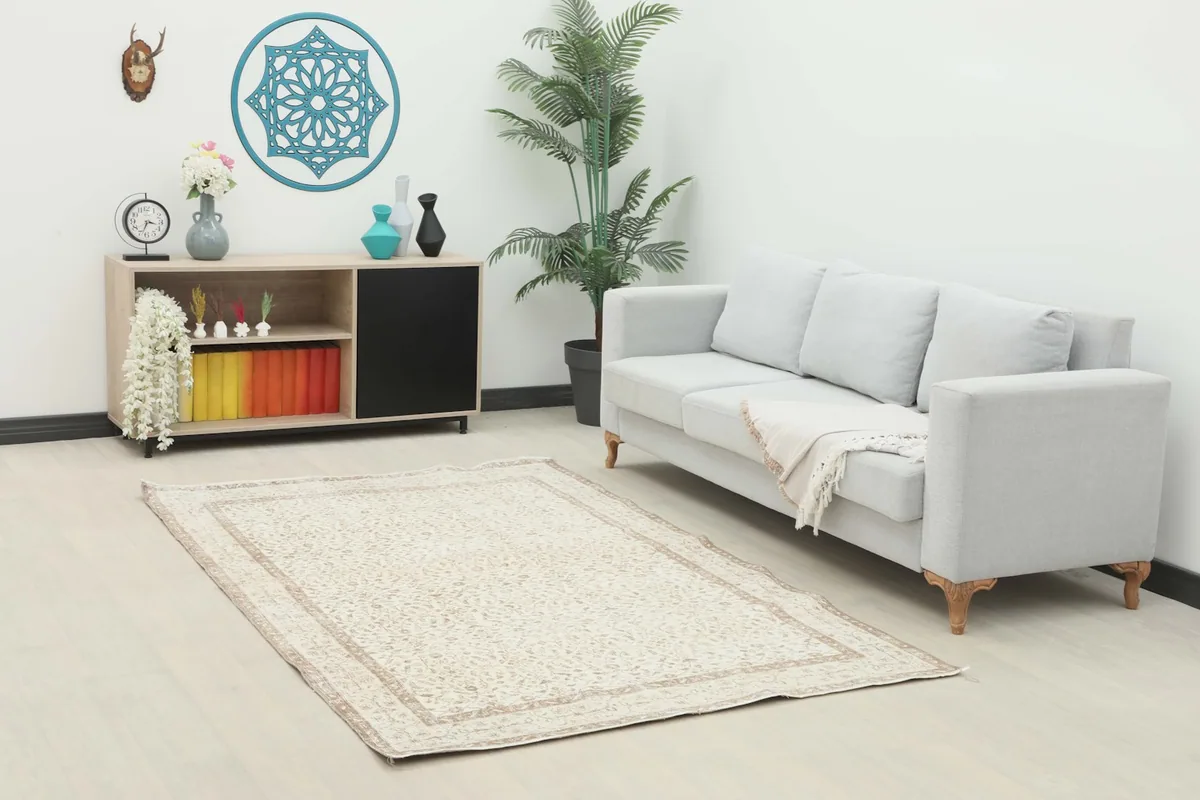 Ivory and beige floral vintage rug placed in a modern living room setting