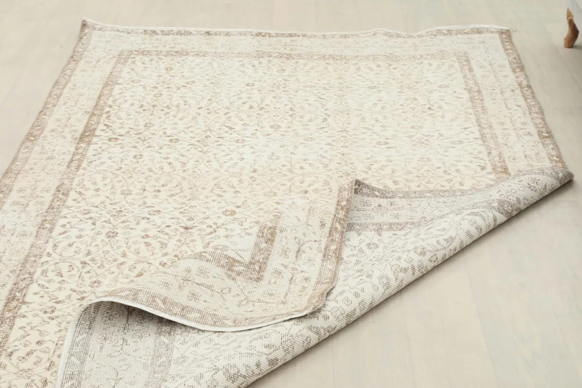 Rug partially folded, displaying the flexibility and construction of the hand-knotted vintage piece