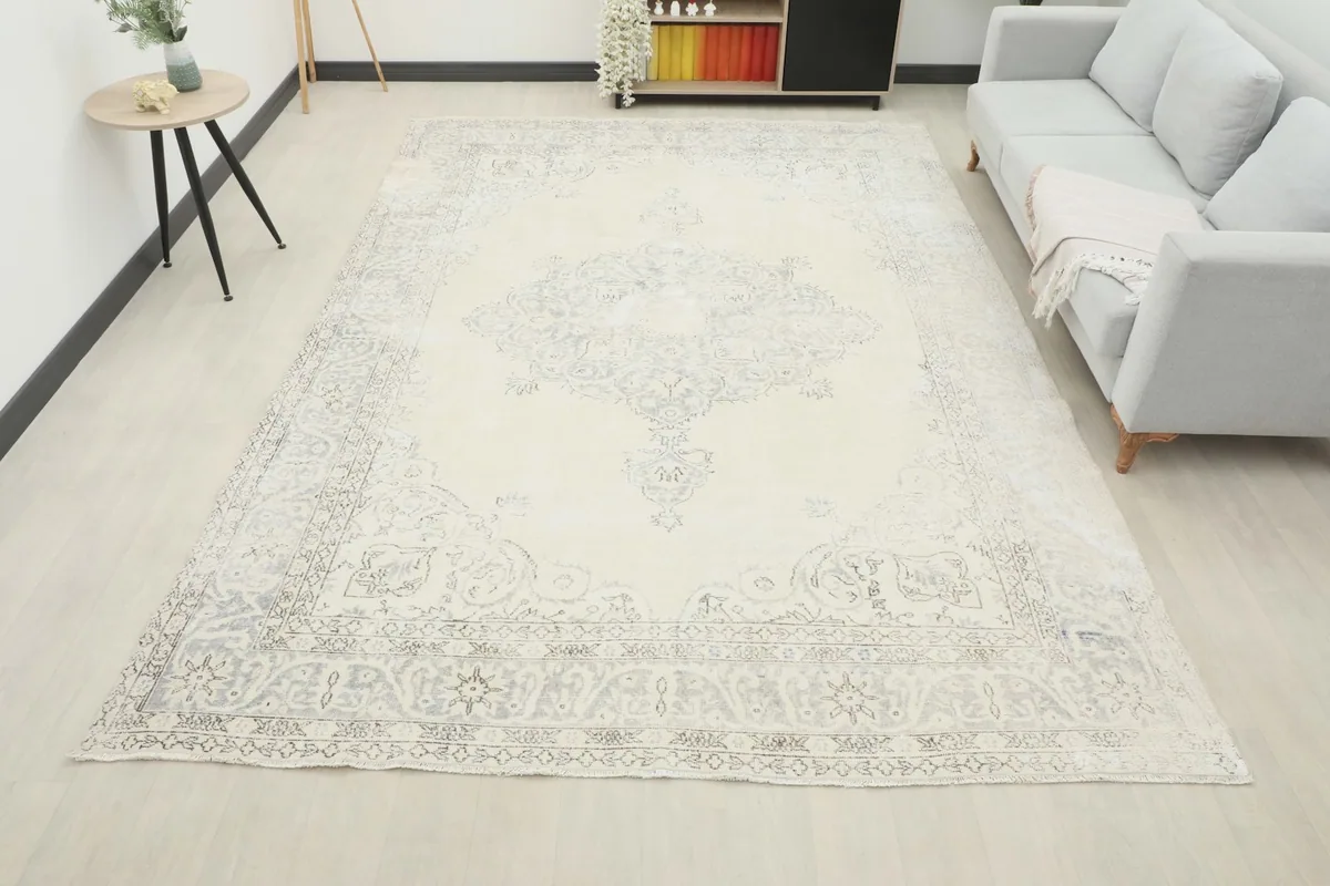 Full room view of the ivory and charcoal vintage rug, demonstrating its large scale and how it anchors the space.