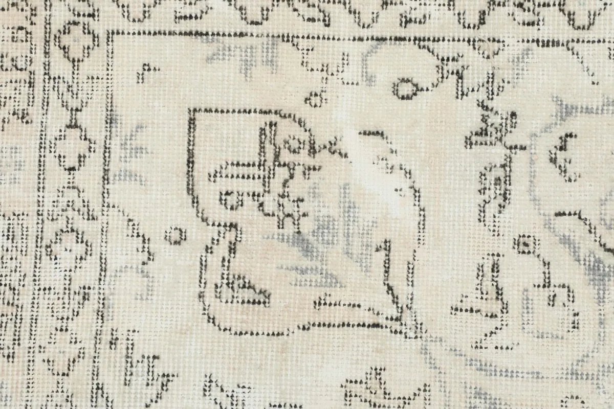Close-up detail of the rug pile, revealing the hand-knotted wool texture and the distressed charcoal patterns.