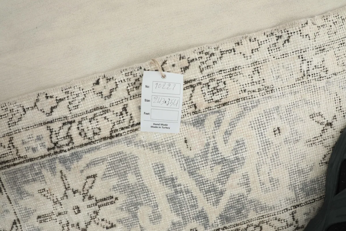 Close-up of the rug's reverse side with a tag, showing the tight hand-knotted weave and cotton foundation.