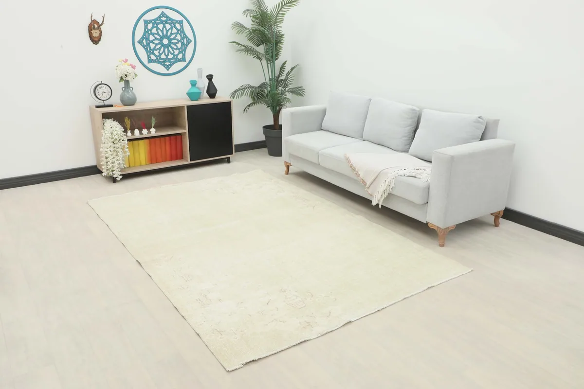 Cream vintage Anatolian rug in a living room setting with a light gray sofa