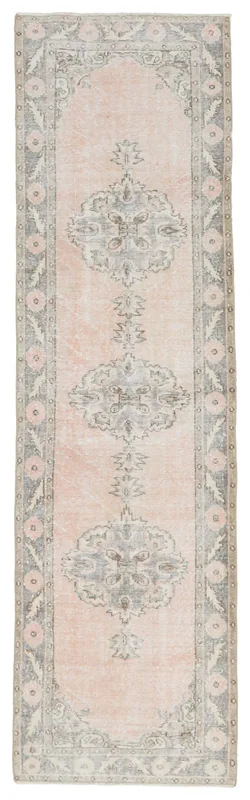 Full overhead view of the vintage rose and gray Anatolian runner rug on a white background.