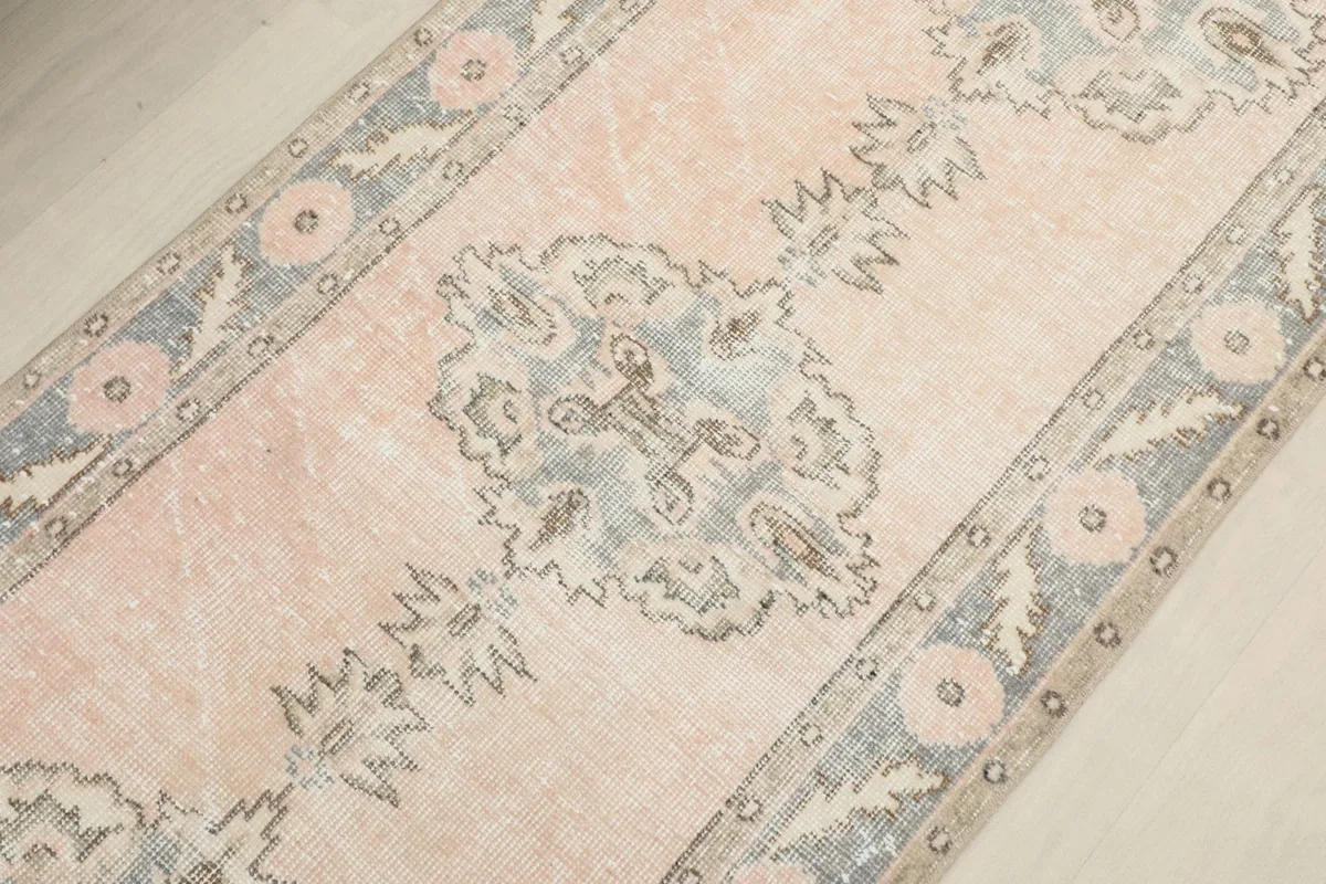 Angled detail shot focusing on a central gray medallion and the surrounding rose field.