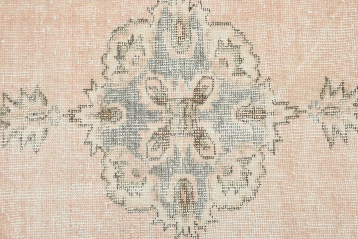 Detailed close-up of one of the gray medallions, showing the hand-knotted texture and color variations.