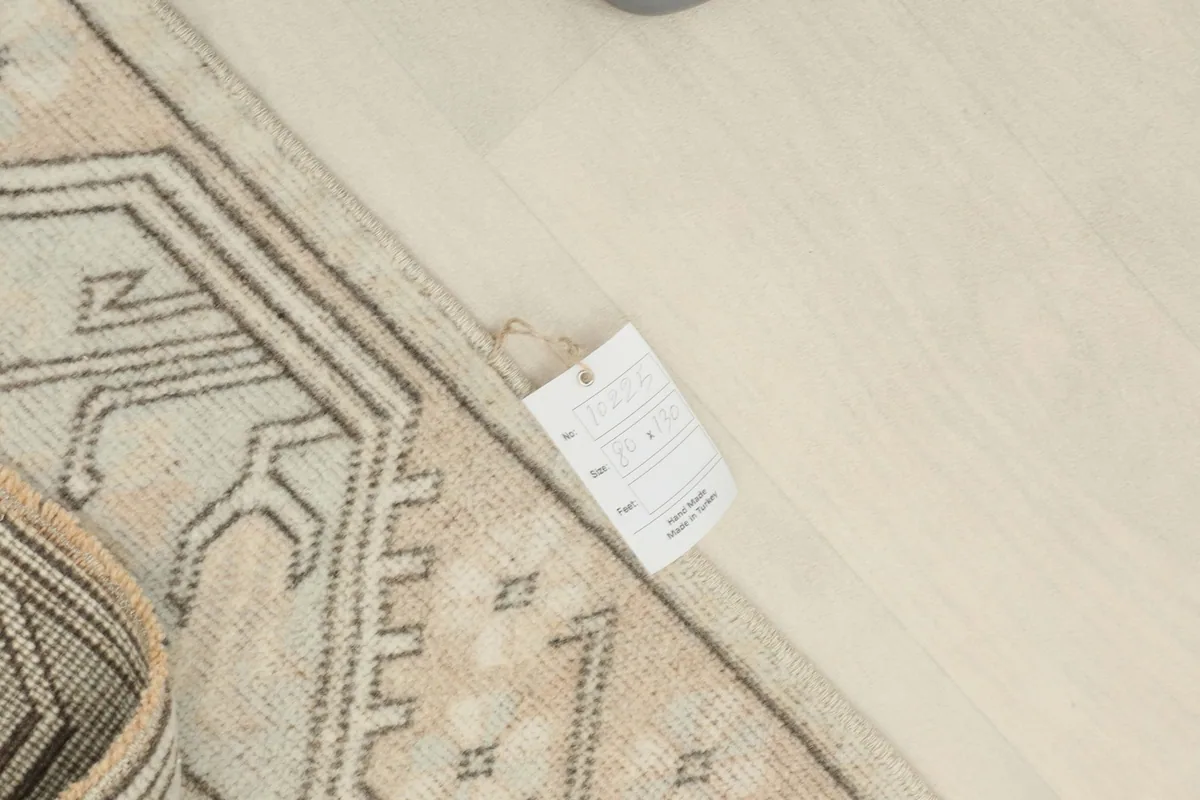View of the rug with a tag, showing its texture and color variations