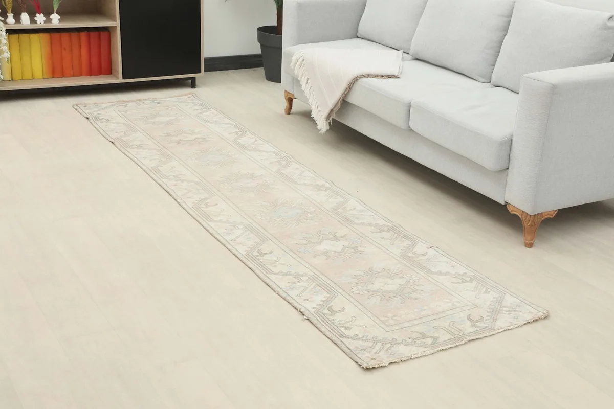 Overhead view of the beige runner rug extending along a wall with a sofa, showcasing its length