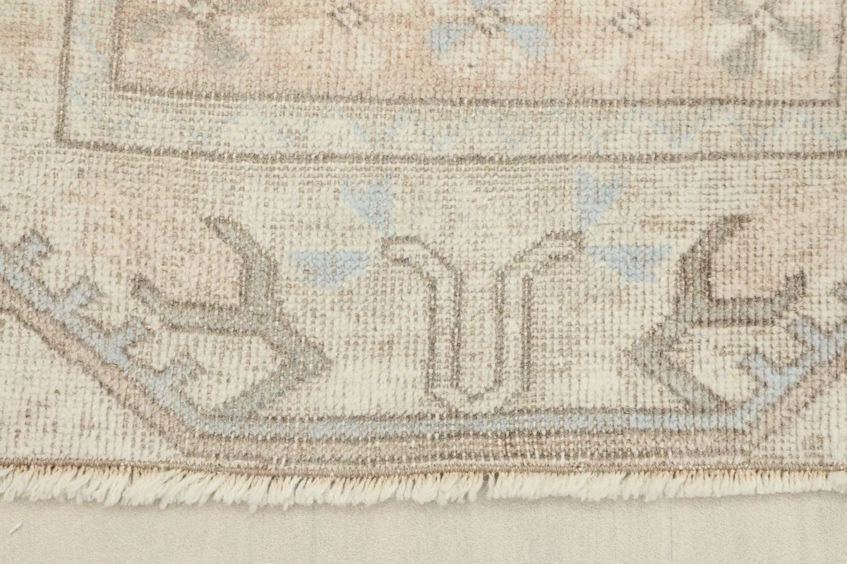 Close-up of the rug's edge and fringe, revealing the hand-knotted construction and cotton foundation