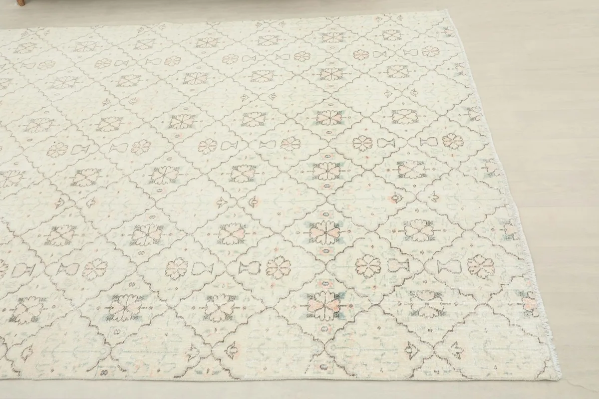 Close-up angled shot of the ivory rug's surface and subtle pattern details