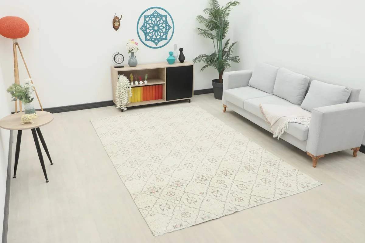 Ivory vintage rug placed in a modern living room setting with a gray sofa