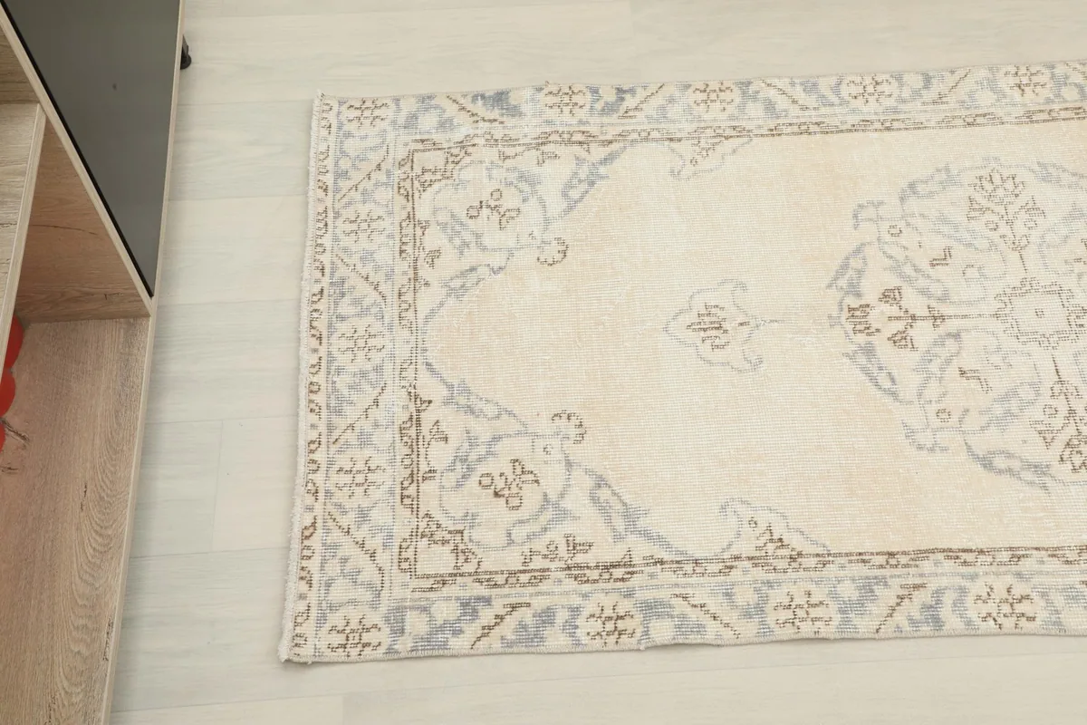 Angled view of the rug's end, showing the intricate border and main field patterns.