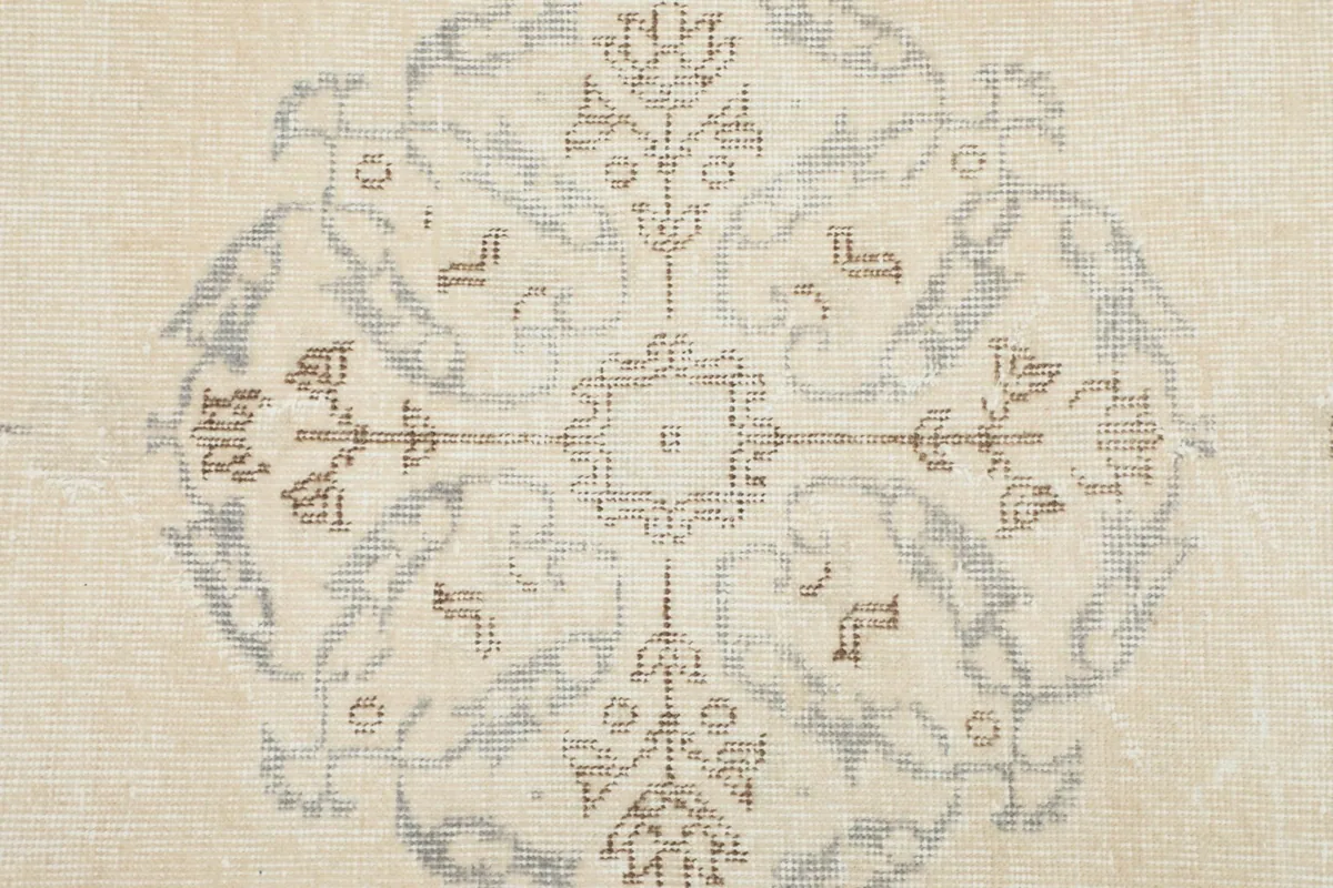 Close-up detail of the hand-knotted wool pile, showing the texture and faded colors of a medallion.