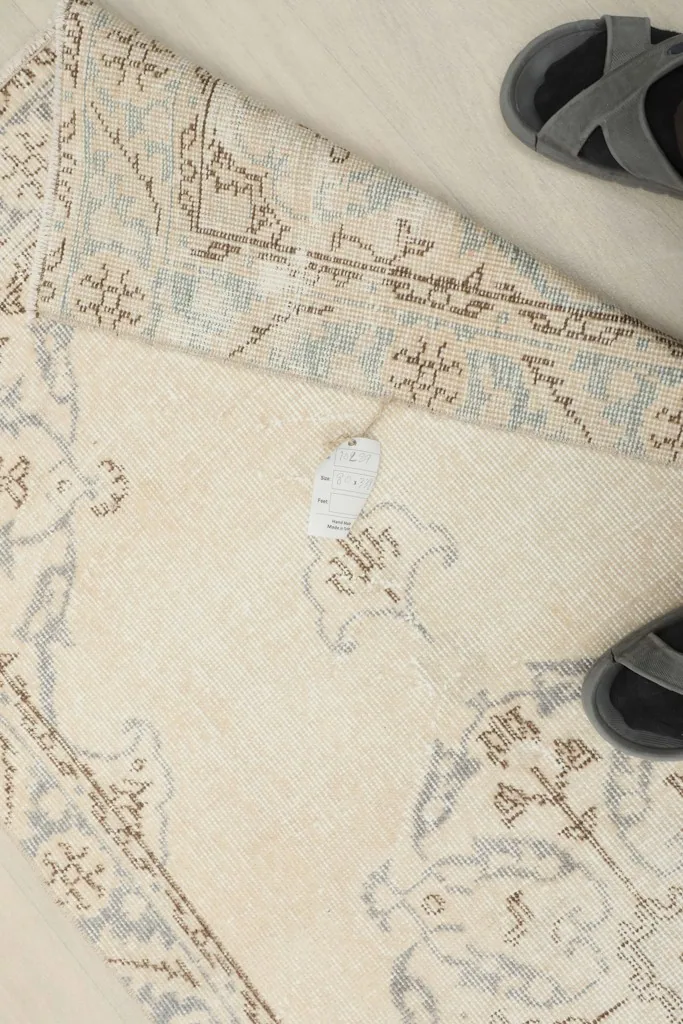 Overhead detail of the rug's reverse side, showing the hand-knotted cotton foundation and wool knots.