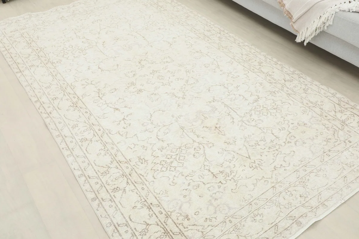 Angled view of the ivory distressed rug, highlighting the subtle floral and medallion patterns.