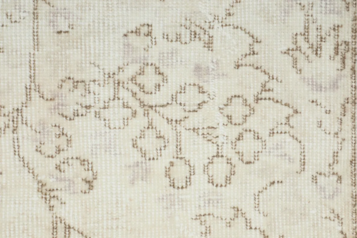 Close-up of the hand-knotted wool pile, revealing the intricate floral pattern and light wear.