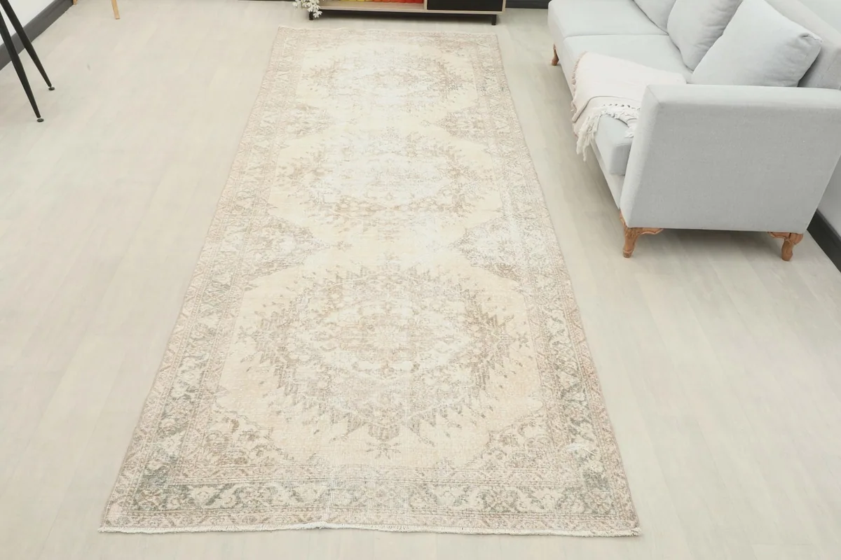 Full room view of the long runner rug extending from a console to a sofa