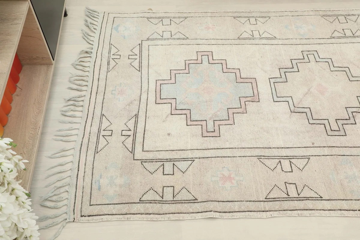 Angled view of the rug's end, highlighting the geometric patterns and fringe.