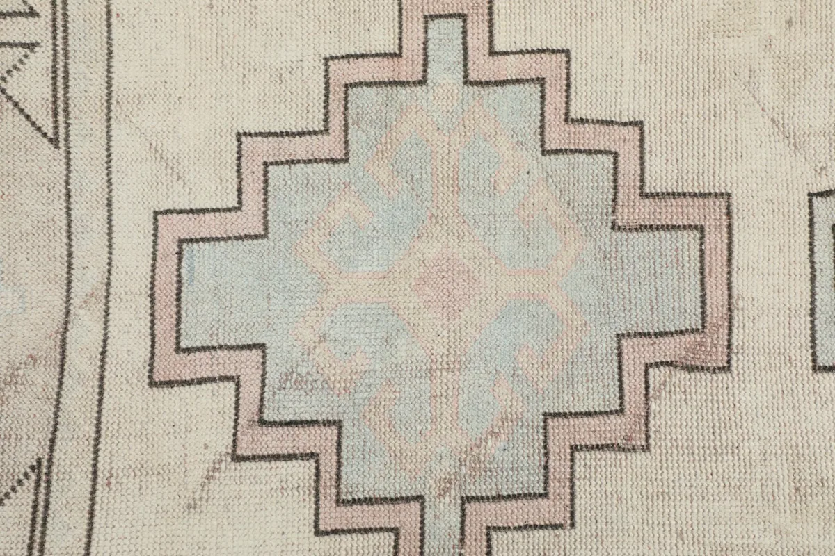Close-up of a central geometric medallion with subtle pink and blue accents.