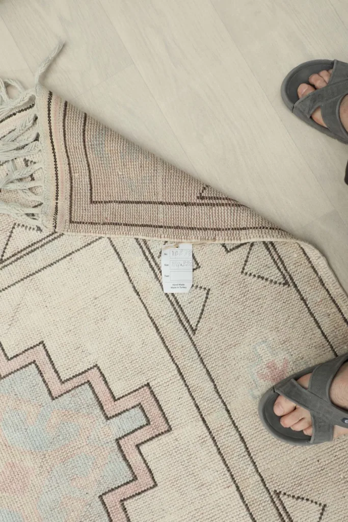 Overhead view of the rug's back and foundation, with a size tag visible.