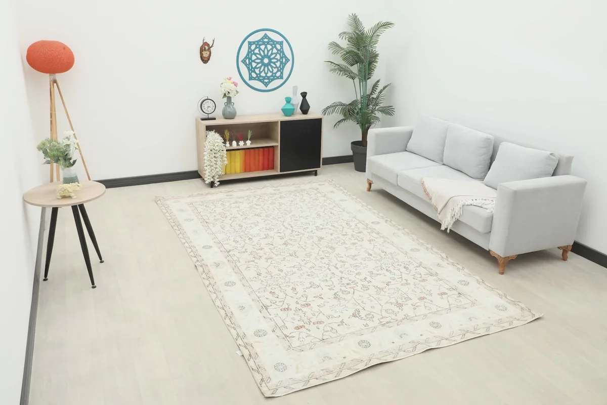 Ivory area rug displayed in a living room setting with a light gray sofa and modern decor.
