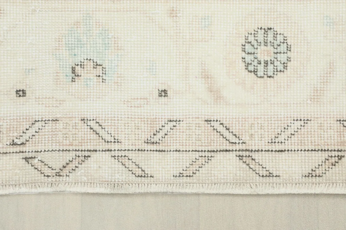 Detail of the outer border with its repeating gray geometric pattern and subtle rose accents.
