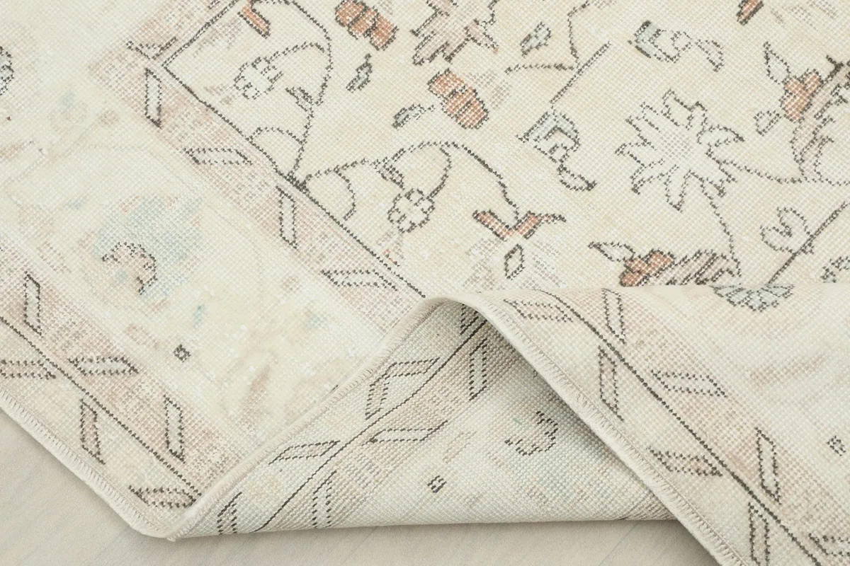 Folded corner of the rug, showing the thickness and the cotton foundation beneath the wool pile.