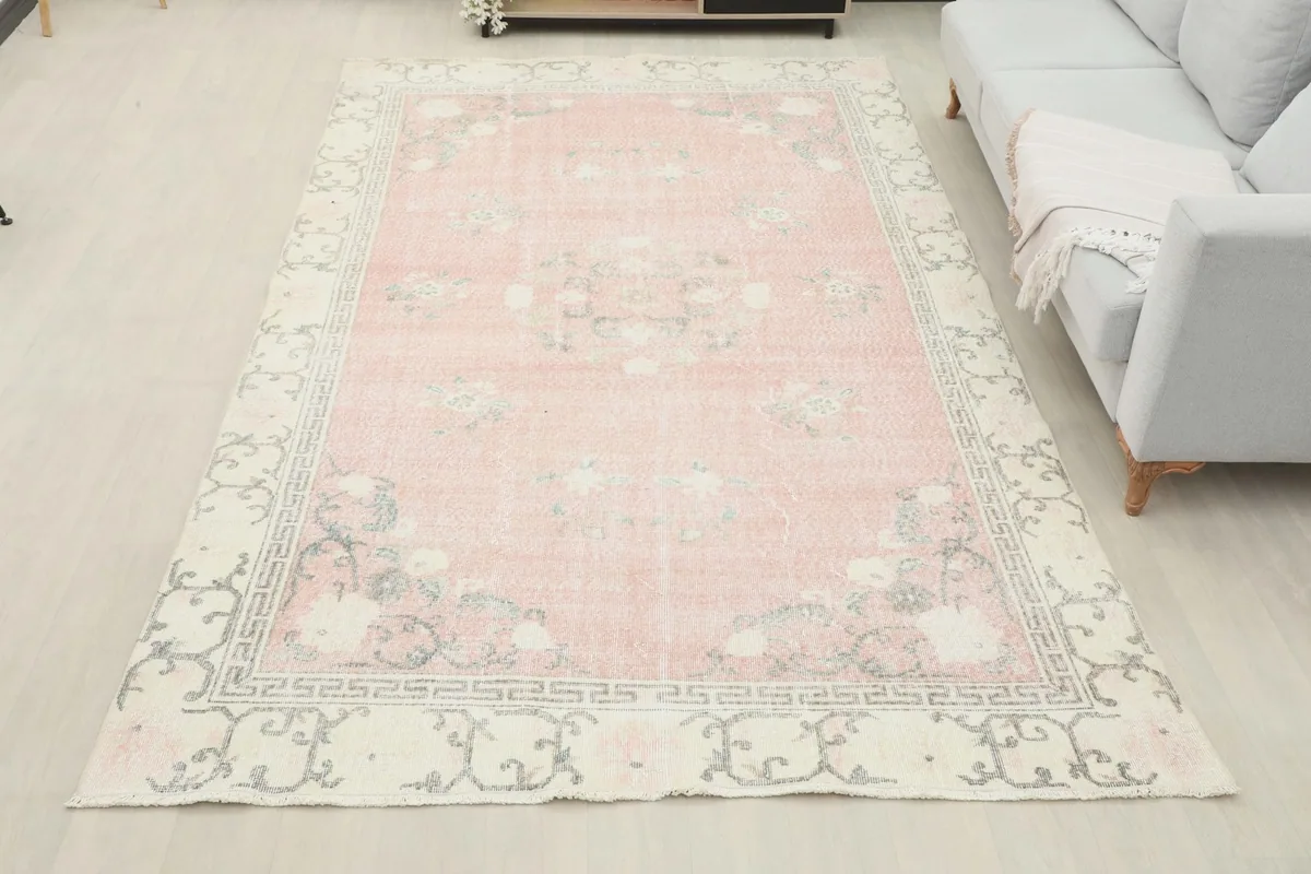 Overhead view of the pink vintage rug in a living room, showcasing its full size and design.
