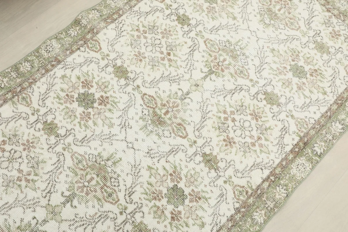 View along the length of the rug, showing the consistent floral pattern and subtle color variations
