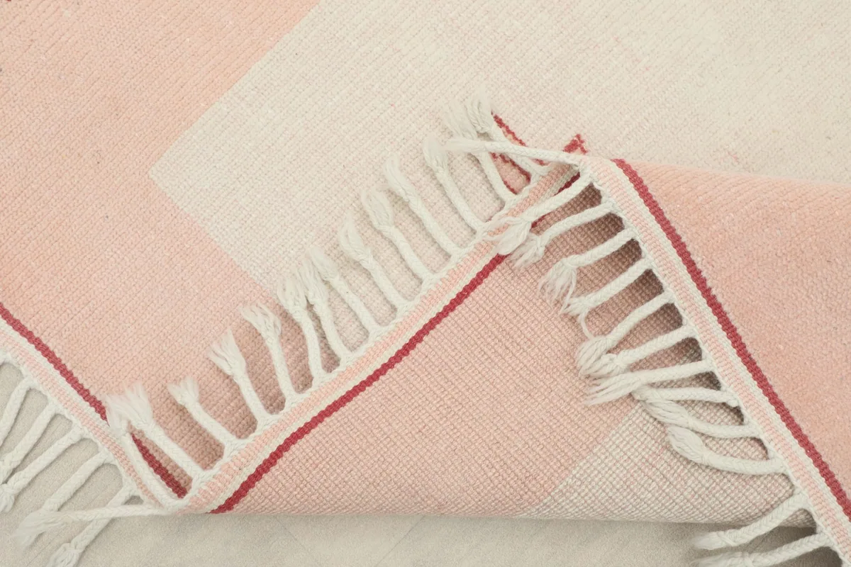 Corner of the rug folded to reveal the cotton foundation and the quality of the hand-knotting.