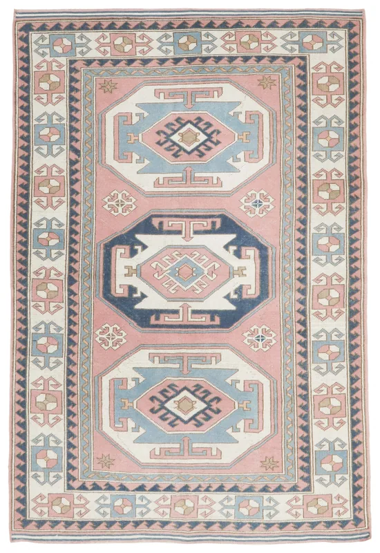 Full overhead view of the vintage pink and blue Anatolian rug on a white background