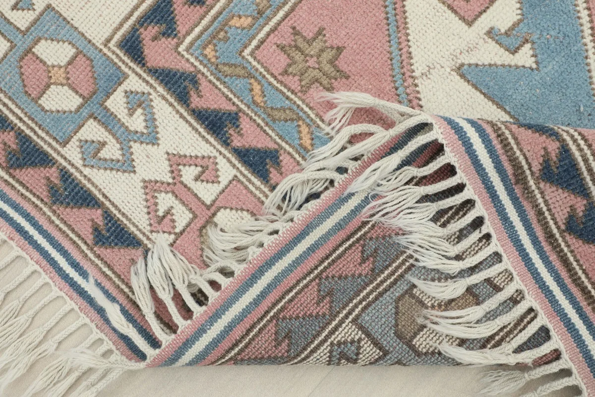 A section of the rug folded to show the thickness and texture of the hand-knotted wool pile