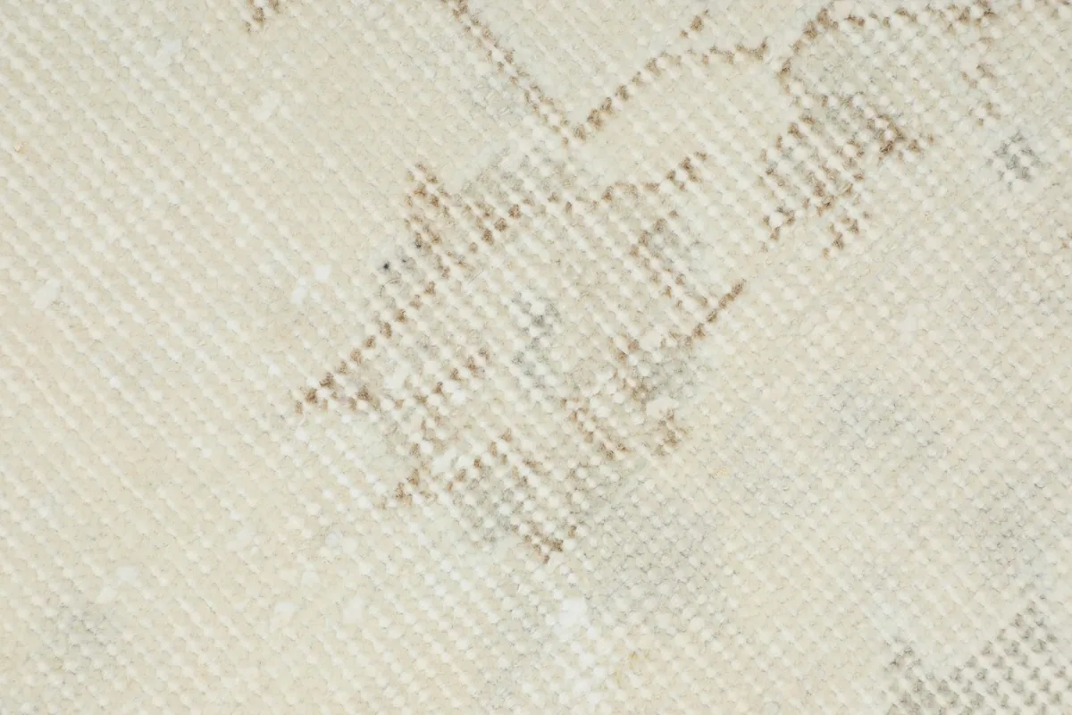 Close-up of the rug's low wool pile texture and faded weave.