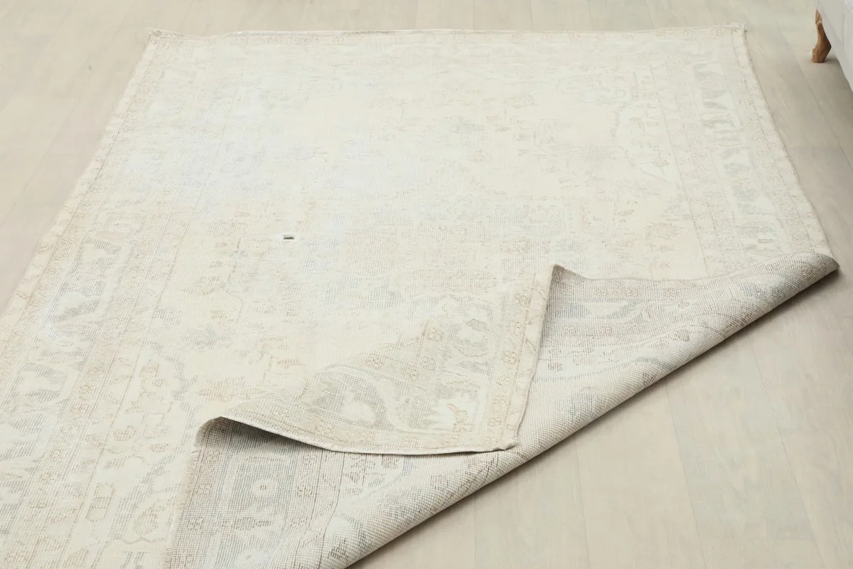 Rug with a corner folded back, revealing the underside and showing the full size.