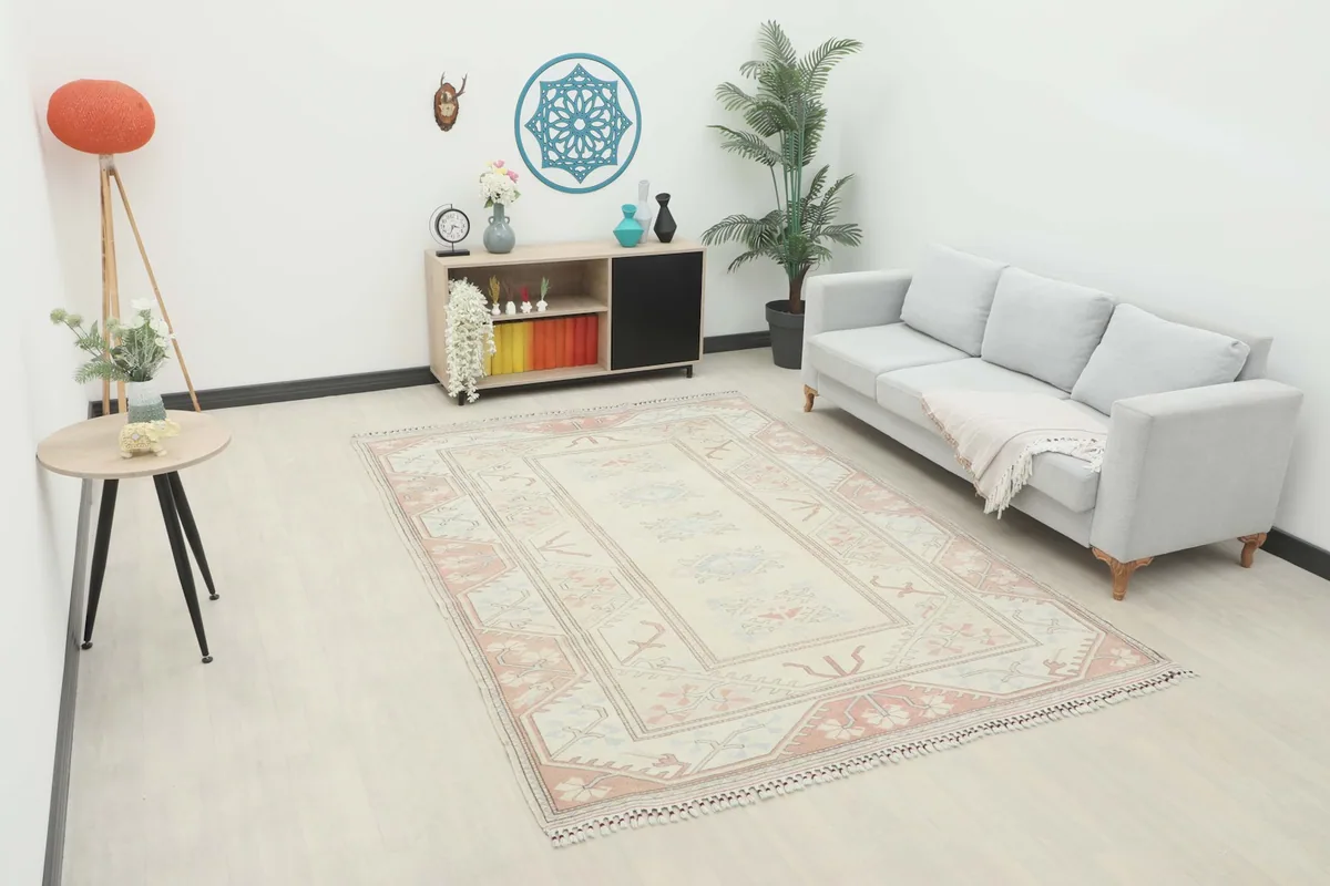 Vintage Anatolian rug displayed in a living room setting with a light gray sofa