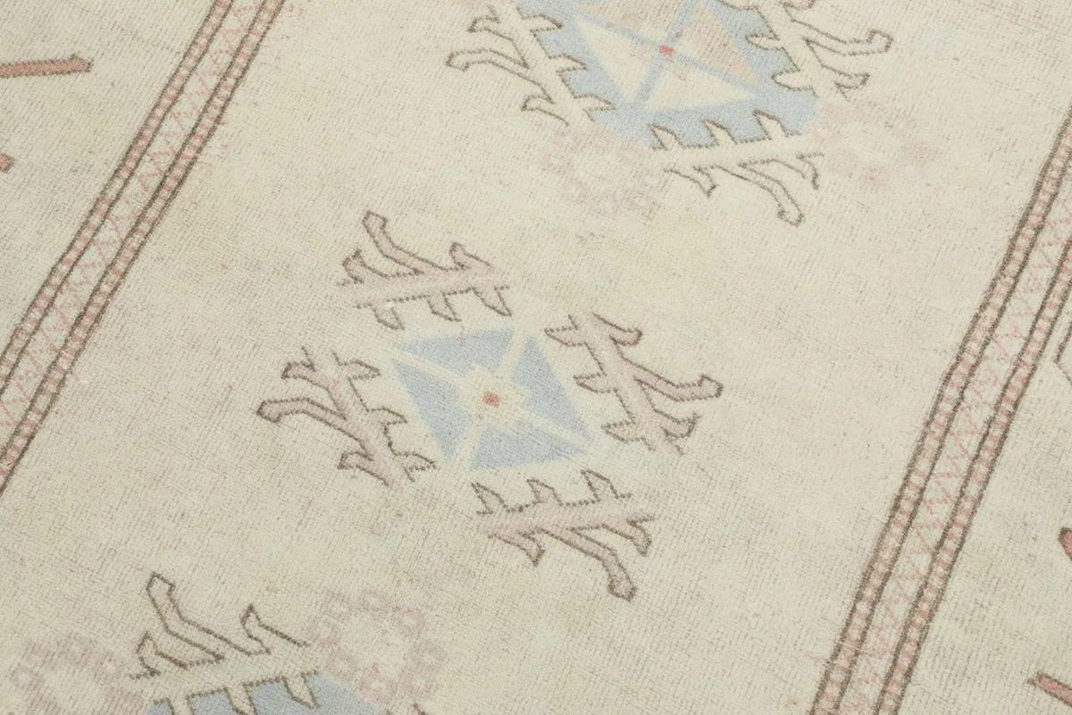 Detailed view of the central ivory field with blue and tan geometric motifs