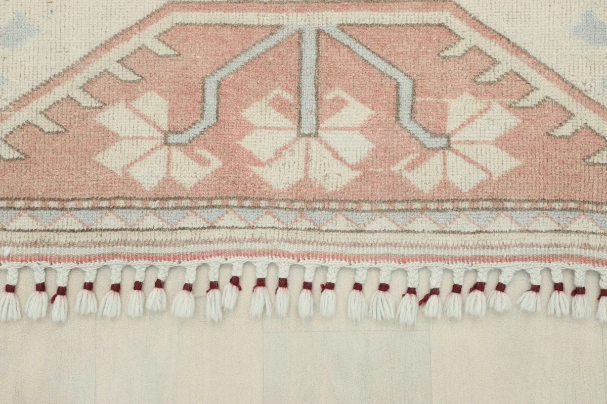 Detail of the rug's fringe and a portion of the rose border with patterns