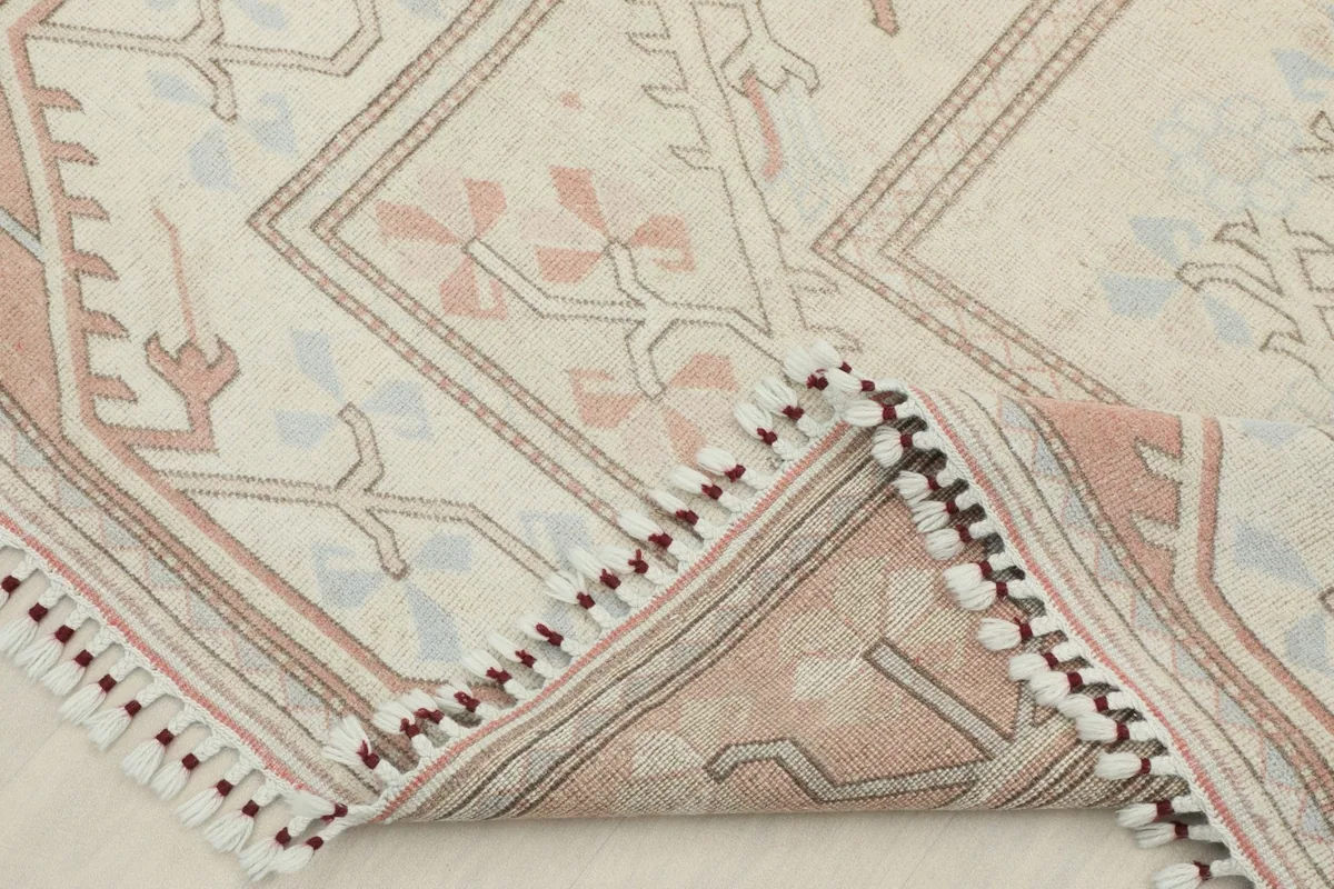 Rug corner folded back to show the hand-knotted cotton foundation and wool pile