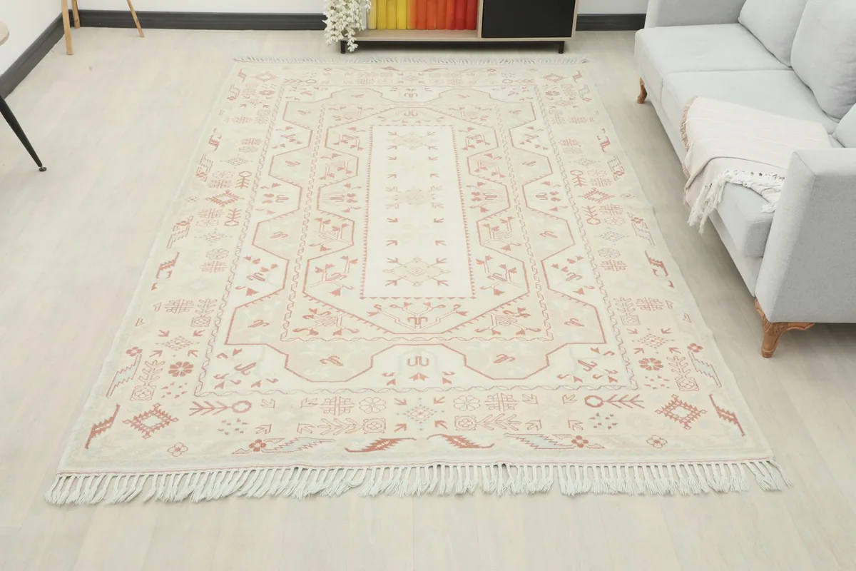 Full view of the cream and rust rug placed in a bright living room setup