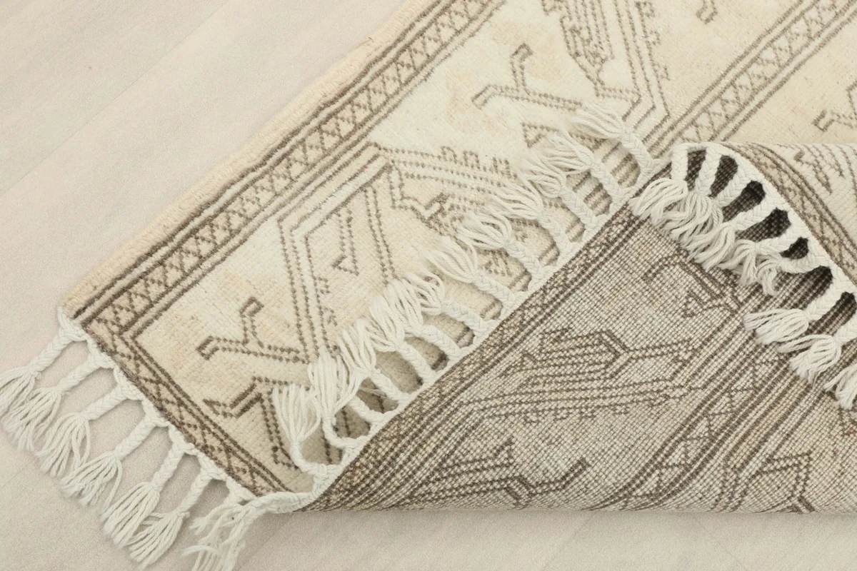 Corner of the rug folded to show the wool pile and cotton foundation