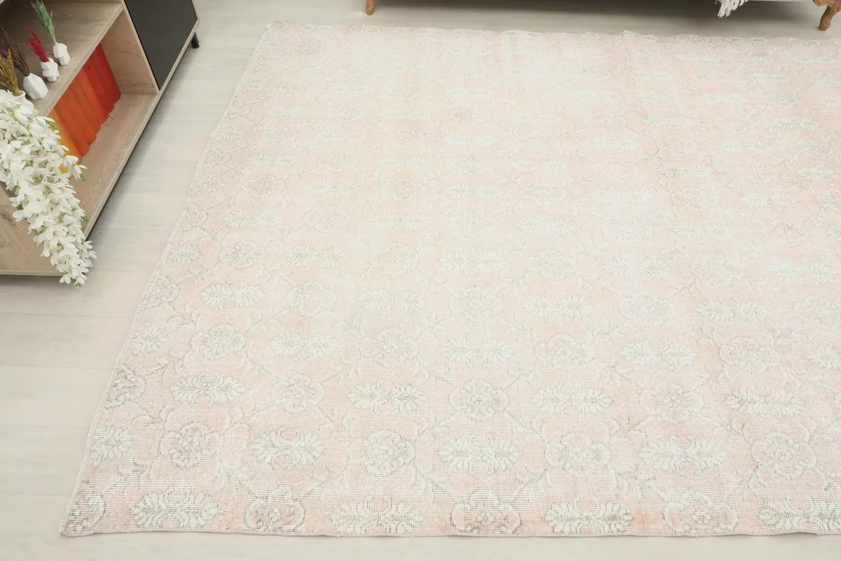 Angled shot of the vintage wool rug, displaying the subtle floral motifs across its surface.