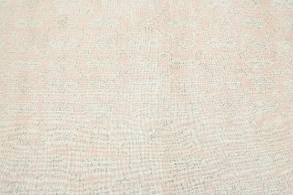Close overhead view of the rose and beige floral pattern, showing the overall design of the rug.